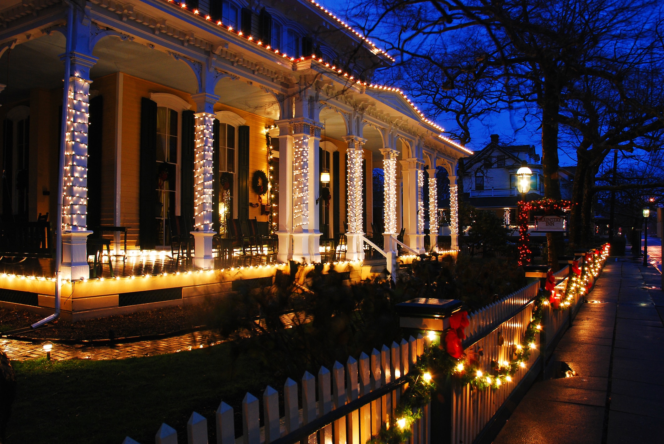 Safely installed Christmas lights brightly decorate a beautiful home at night.